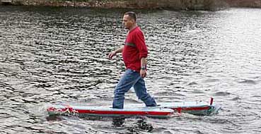 April 2002:   Newton, MA:  Yoav Rosen with a prototype of his walking-on-water
floatation apparatus, for which he received patent number 6,764,363. The
apparatus comprises a pair of bouyant wing-shaped floats and foot wells in the
floats designed to be under the center of boyancy in each float.  (Handout photo...